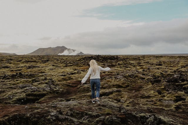 A woman walking the land in Iceland.